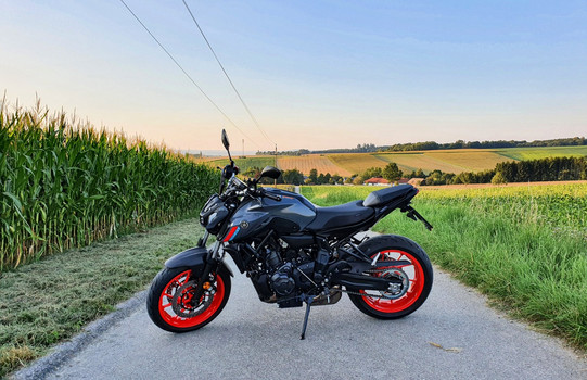 Ein Motorrad steht auf einem Feldweg.