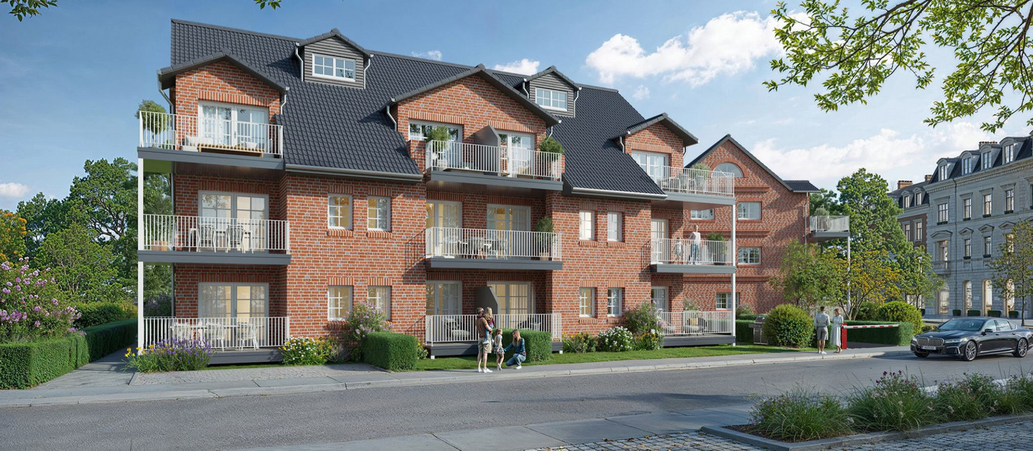 Ansicht eines großen Mehrfamilienhauses mit vielen Balkonen in einer grünen Nebenstraße. Das Haus hat rotes Gemäuer und ein schwarzes Dach.