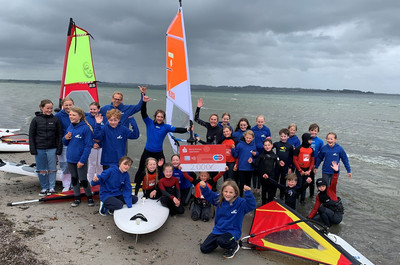 Jubelnde Kinder mit Surfbrettern am Strand