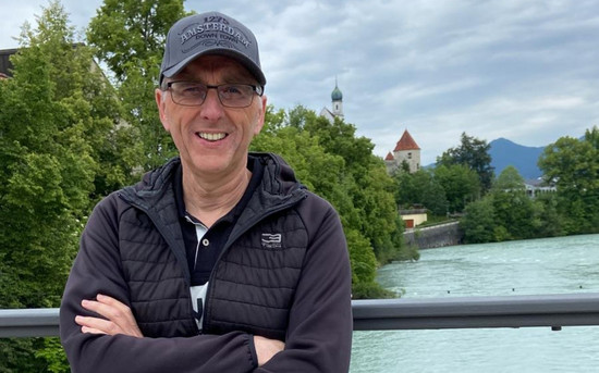 Stephan Röhr auf einem privaten Ausflug in eine Altstadt im Hintergrund ist ein Fluss und ein Kirchturm zu sehen